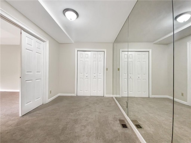 unfurnished bedroom with two closets and carpet