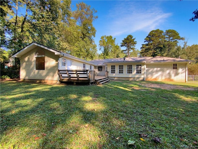 back of house with a deck and a lawn