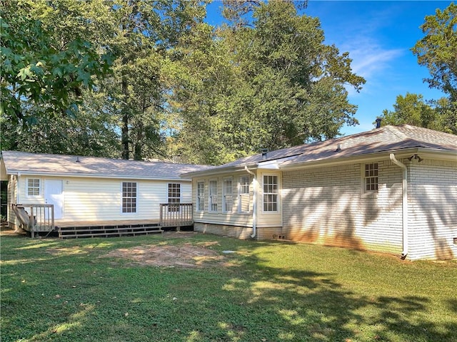 rear view of property featuring a lawn and a wooden deck