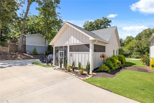 exterior space with a sunroom and a lawn