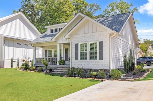 rear view of property featuring a porch and a lawn