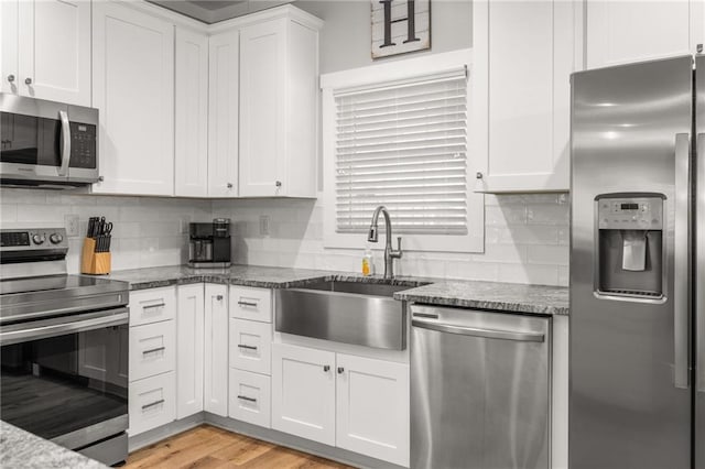 kitchen featuring appliances with stainless steel finishes, sink, and white cabinets