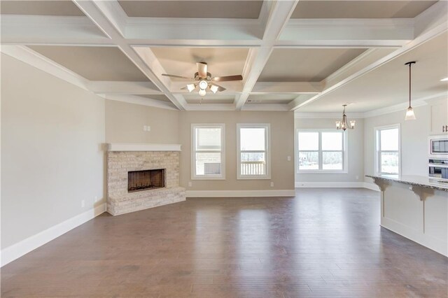 unfurnished living room featuring coffered ceiling, dark wood-type flooring, and a wealth of natural light