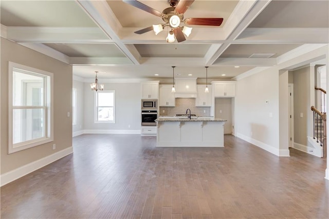 unfurnished living room with beam ceiling, coffered ceiling, and dark wood-type flooring