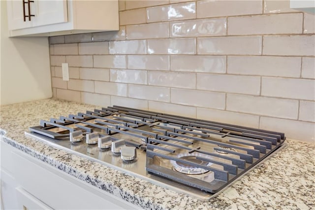 room details featuring tasteful backsplash and stainless steel gas stovetop