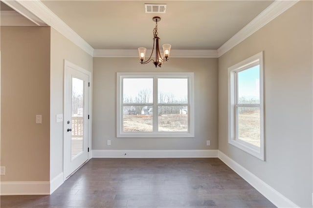 empty room featuring dark hardwood / wood-style flooring, ornamental molding, and a chandelier