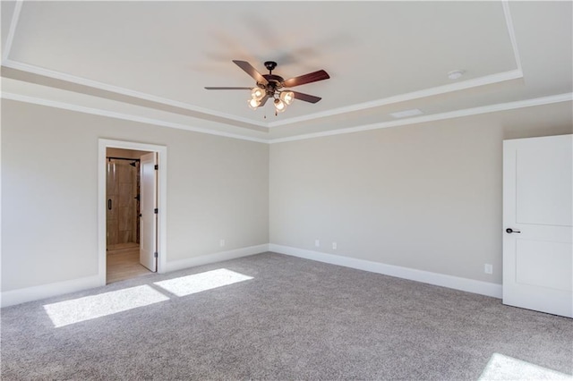 unfurnished room with ceiling fan, crown molding, light carpet, and a tray ceiling