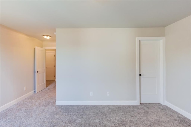 spare room featuring light carpet