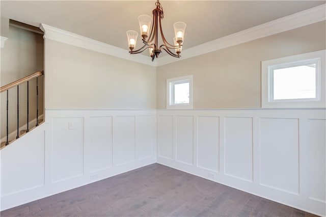 spare room with crown molding, dark hardwood / wood-style flooring, and a chandelier