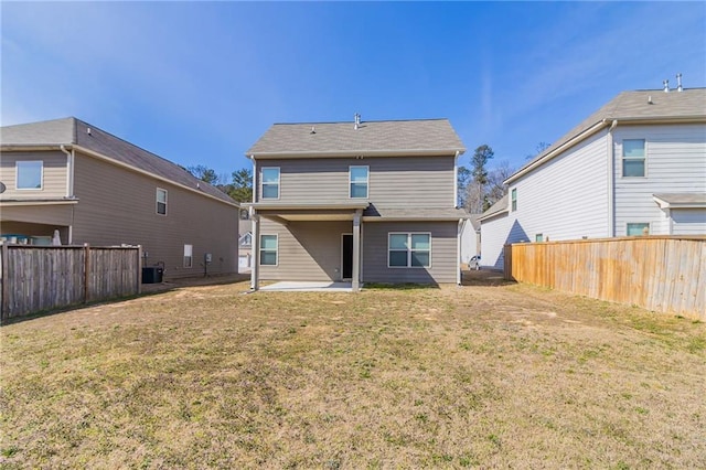 back of property with a lawn, a patio area, and fence