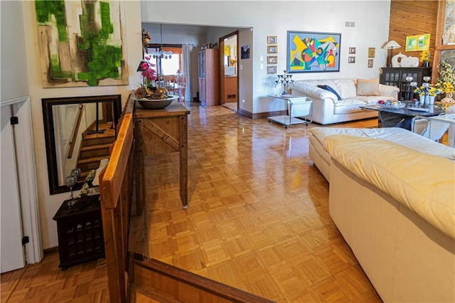 living room with light parquet floors and an inviting chandelier