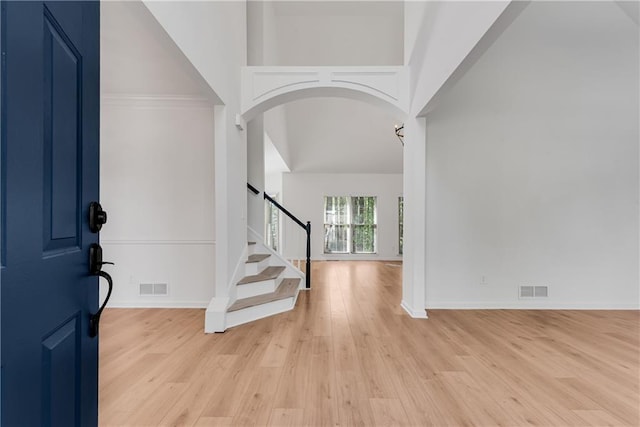 4414 Aldenham Way, Suwanee, GA 30024 - entryway with arched walkways, light wood-style floors, baseboards, stairs, and a towering ceiling