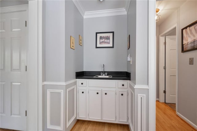 4423 Windsor Oaks Cir, Marietta, GA 30066 - bar area featuring a sink, light wood-style floors, crown molding, and baseboards