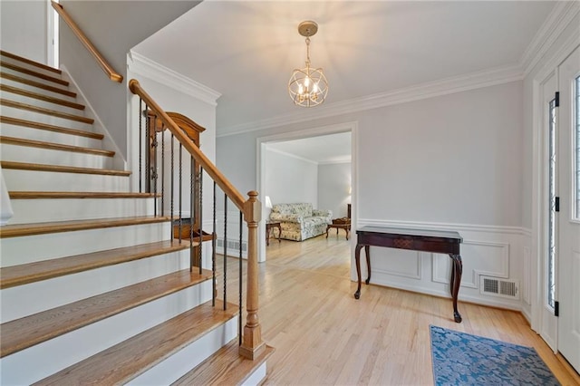 4423 Windsor Oaks Cir, Marietta, GA 30066 - stairway featuring a chandelier, plenty of natural light, crown molding, and wood finished floors