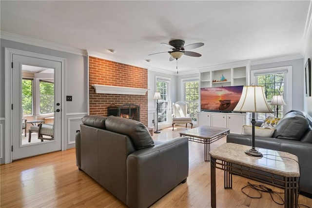 4423 Windsor Oaks Cir, Marietta, GA 30066 - living area with ceiling fan, ornamental molding, a fireplace, light wood-style flooring, and a wainscoted wall