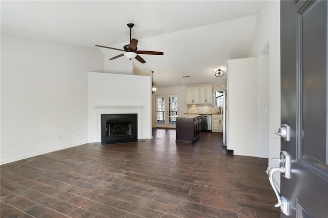 unfurnished living room with high vaulted ceiling, dark hardwood / wood-style floors, and ceiling fan