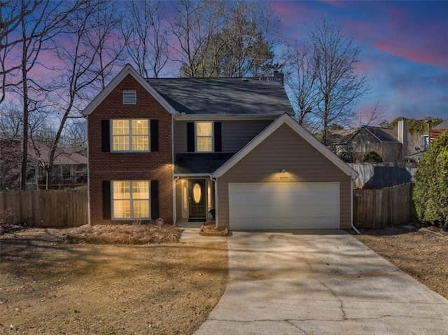 traditional-style house with brick siding, fence, driveway, and an attached garage