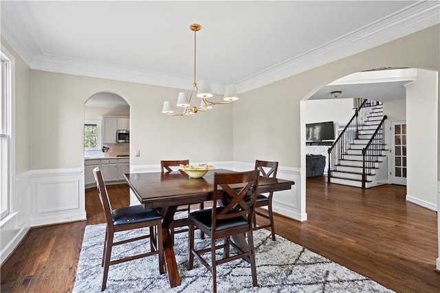 410 Hickory Fairway Ct, Woodstock, GA 30188 - dining area featuring arched walkways, ornamental molding, dark wood-style floors, stairs, and a chandelier