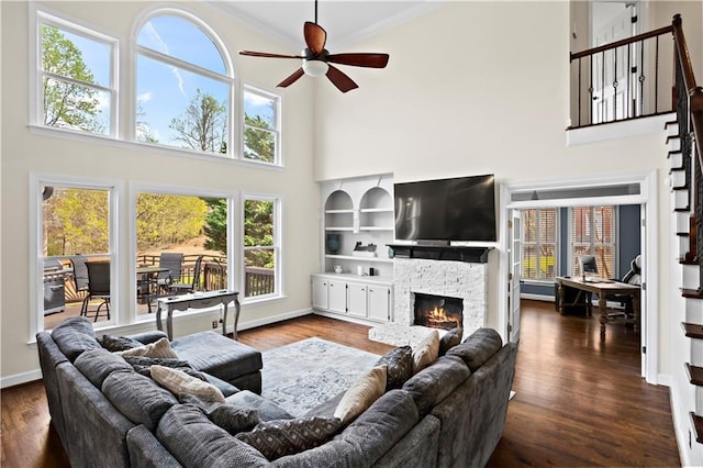 410 Hickory Fairway Ct, Woodstock, GA 30188 - living area with a towering ceiling, a ceiling fan, a fireplace, crown molding, and dark wood-style floors