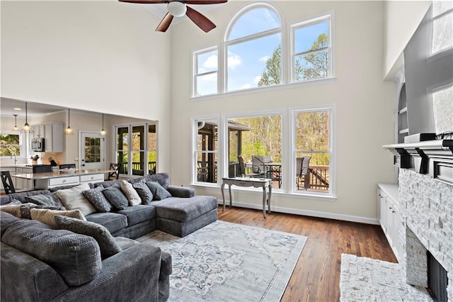 410 Hickory Fairway Ct, Woodstock, GA 30188 - living area featuring a towering ceiling, ceiling fan, healthy amount of natural light, wood finished floors, and baseboards