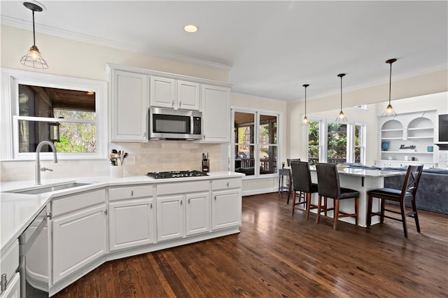 410 Hickory Fairway Ct, Woodstock, GA 30188 - kitchen with stainless steel appliances, a sink, crown molding, dark wood-style flooring, and white cabinetry