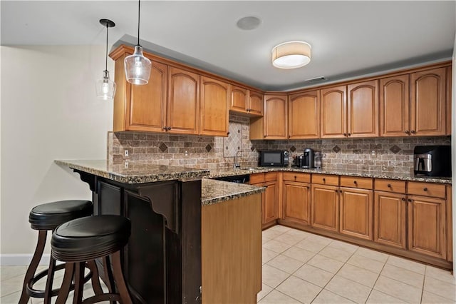 410 Hickory Fairway Ct, Woodstock, GA 30188 - kitchen with black microwave, a breakfast bar, a peninsula, and brown cabinets