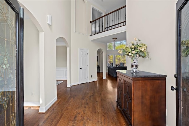 410 Hickory Fairway Ct, Woodstock, GA 30188 - entryway with arched walkways, a towering ceiling, dark wood finished floors, and baseboards