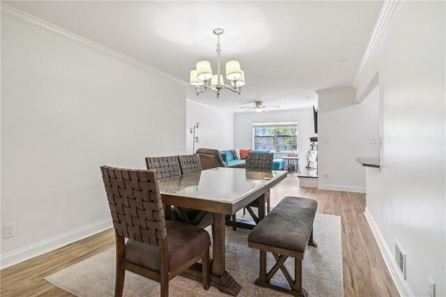 dining space featuring ceiling fan with notable chandelier, light wood-type flooring, and ornamental molding