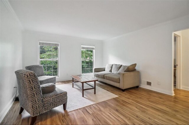 living room featuring light wood-type flooring and ornamental molding