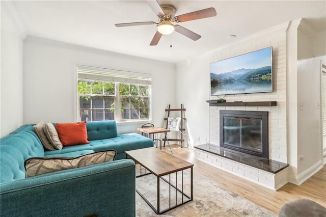 living room with a fireplace, ornamental molding, hardwood / wood-style floors, and ceiling fan