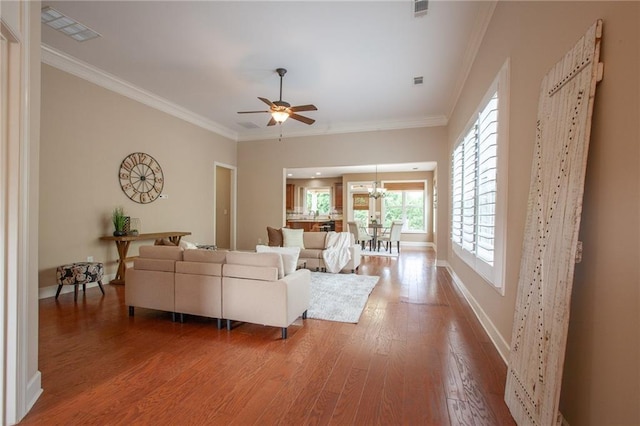 living room with crown molding, wood finished floors, and visible vents