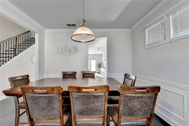 dining space with visible vents, a wainscoted wall, crown molding, and stairway