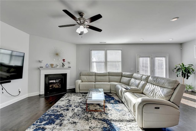 living area with dark wood-style floors, baseboards, a ceiling fan, recessed lighting, and a glass covered fireplace