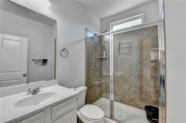 bathroom featuring vanity, toilet, and a stall shower