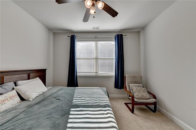 carpeted bedroom featuring visible vents, a ceiling fan, and baseboards