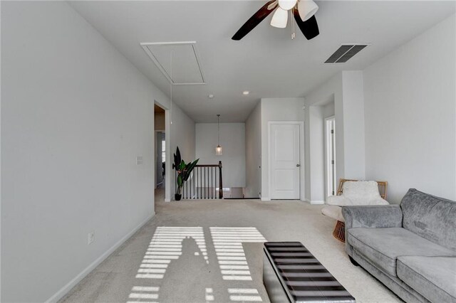 unfurnished living room featuring visible vents, ceiling fan, baseboards, attic access, and light carpet
