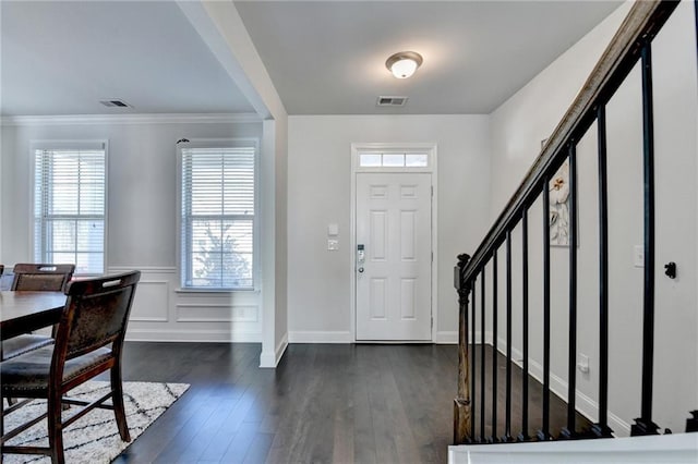 foyer featuring crown molding, stairway, visible vents, and dark wood-style flooring