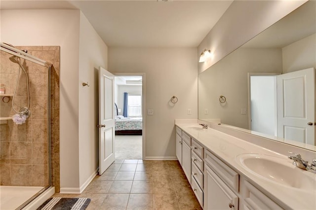 ensuite bathroom featuring a sink, baseboards, double vanity, and a shower stall