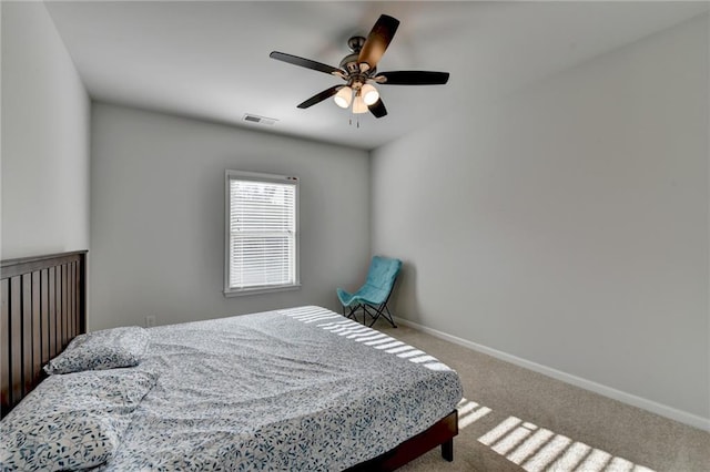 carpeted bedroom with visible vents, baseboards, and ceiling fan