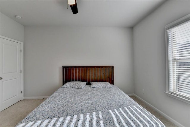 carpeted bedroom with ceiling fan and baseboards