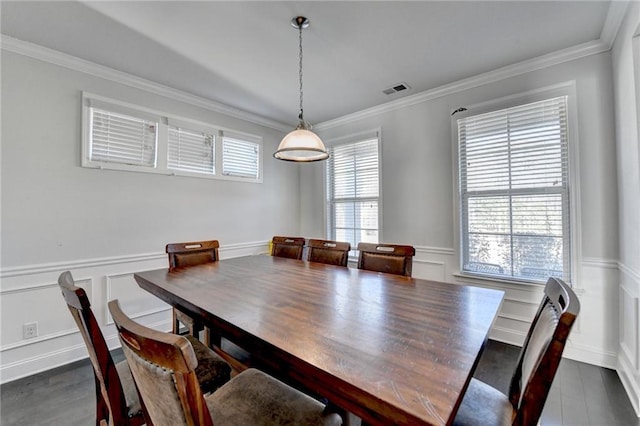 dining area with visible vents, ornamental molding, wainscoting, a decorative wall, and dark wood-style flooring
