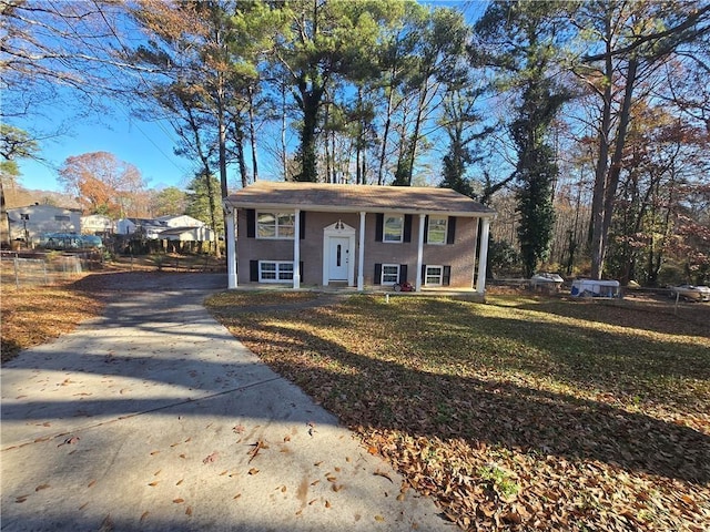 view of front facade featuring concrete driveway and a front lawn