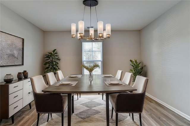 dining space with hardwood / wood-style flooring and a notable chandelier