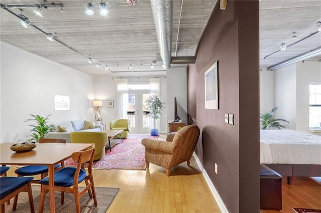 interior space with wood-type flooring, rail lighting, and french doors