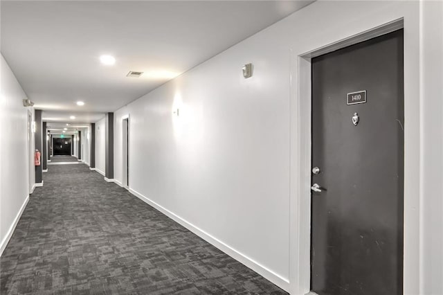 hallway featuring dark carpet