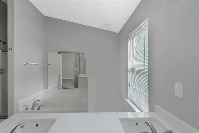 1011 Riverclift Dr, Covington, GA 30016 - bathroom with a jetted tub and vaulted ceiling