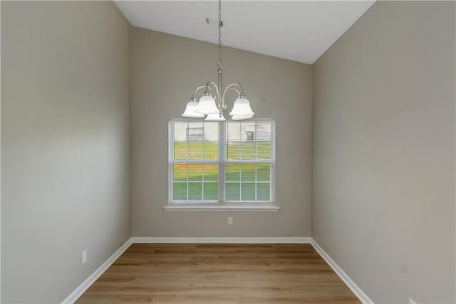 1011 Riverclift Dr, Covington, GA 30016 - empty room with a chandelier, light wood-style floors, vaulted ceiling, and baseboards