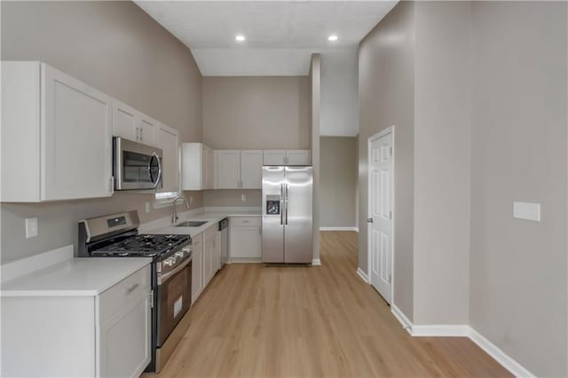 1011 Riverclift Dr, Covington, GA 30016 - kitchen featuring stainless steel appliances, a sink, light wood-style floors, baseboards, and light countertops
