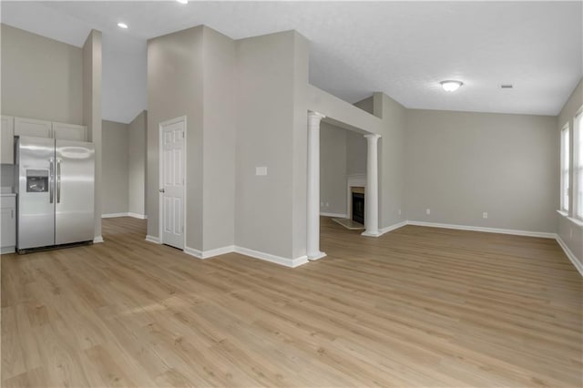 1011 Riverclift Dr, Covington, GA 30016 - unfurnished living room with baseboards, light wood-style flooring, lofted ceiling, a fireplace, and recessed lighting