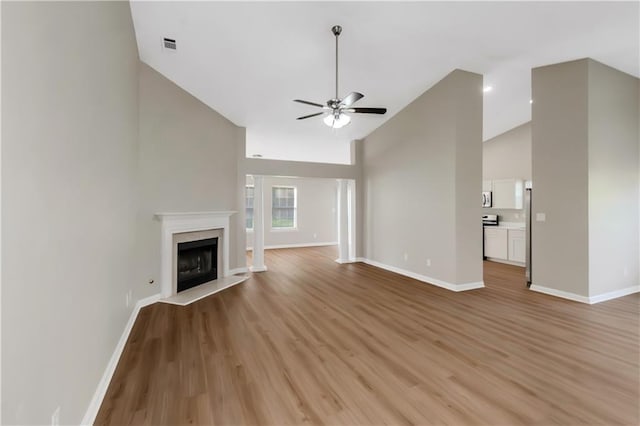 1011 Riverclift Dr, Covington, GA 30016 - unfurnished living room with high vaulted ceiling, ceiling fan, baseboards, light wood finished floors, and a fireplace